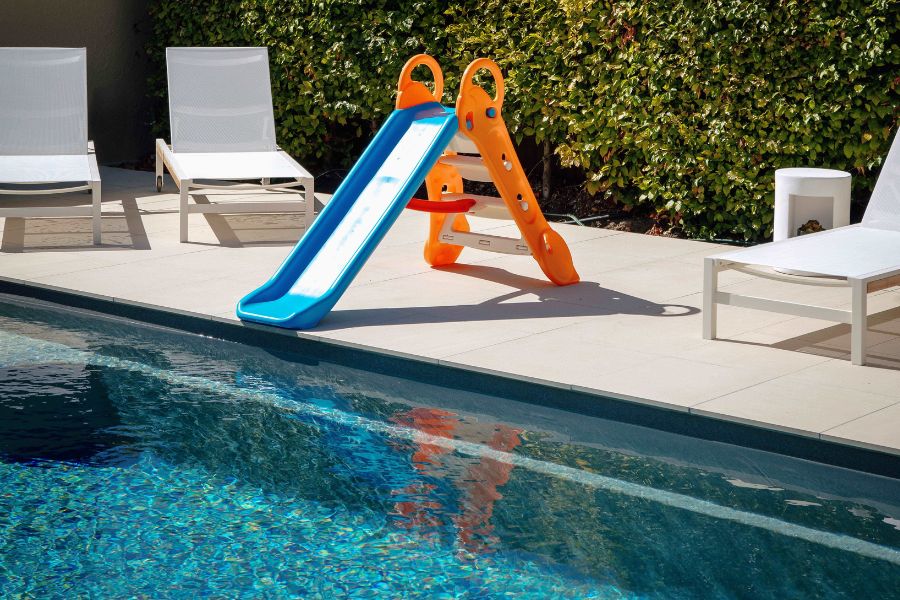 Kiwi family playing in a Compass X-Trainer fibreglass pool in a New Zealand backyard